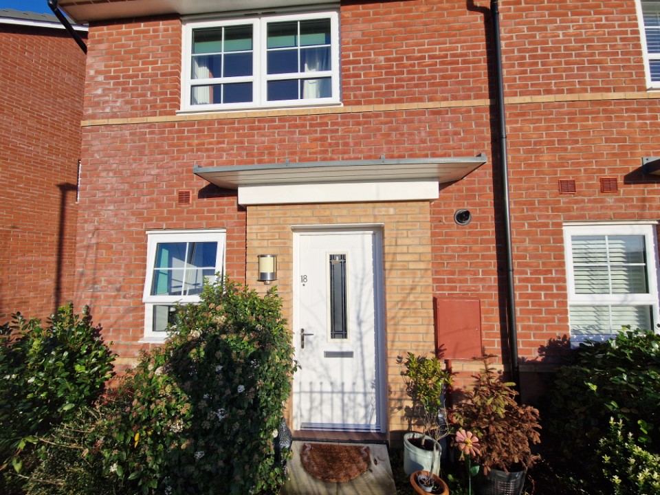 Image of red brick house with a white front door.