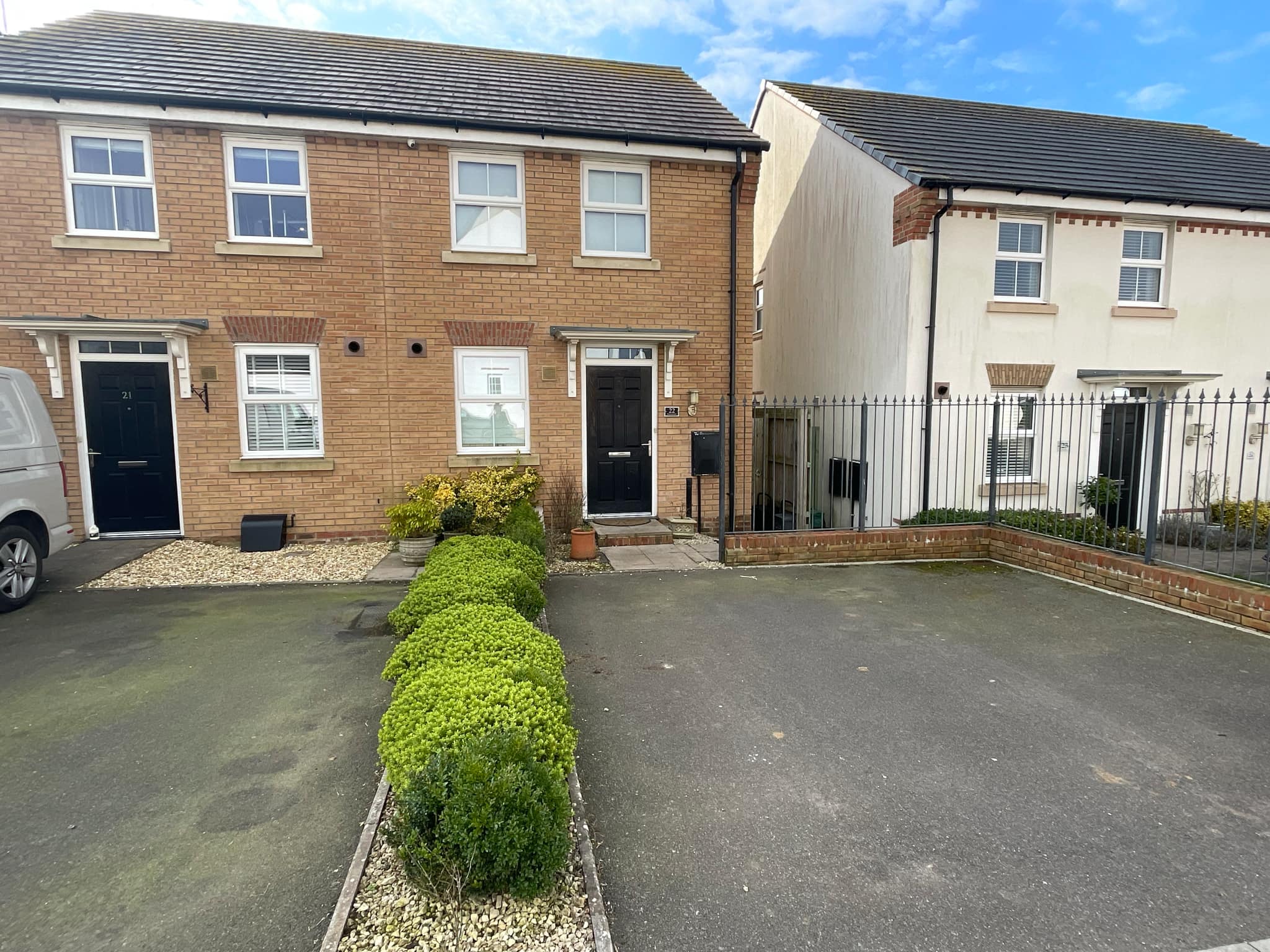 Photo of a house with a black front door and a double parking space.